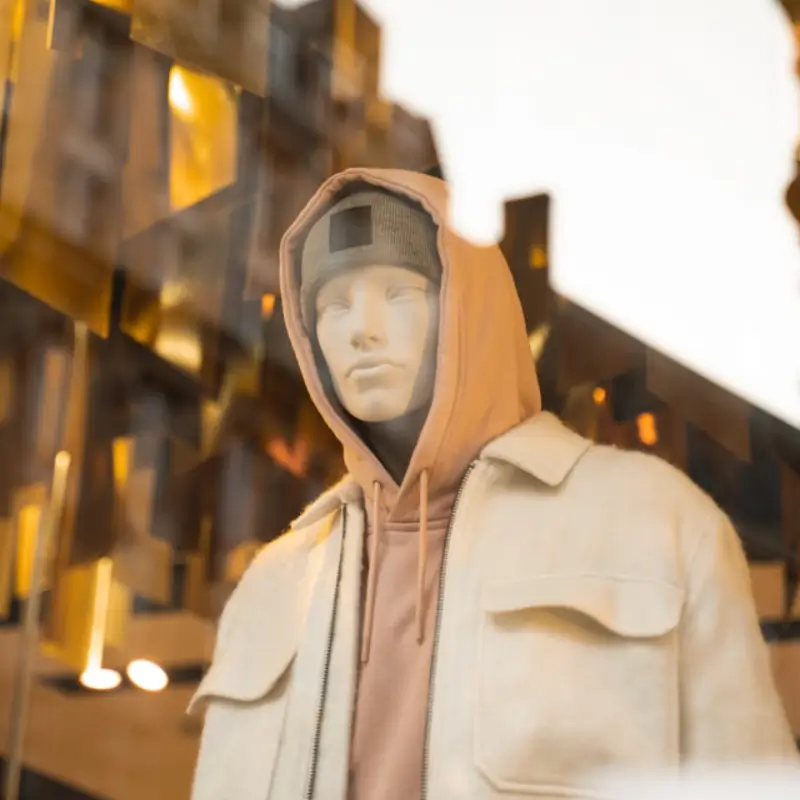 mannequin behind a window, wearing a hoodie, jacket and a hat